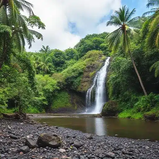 lush waterfall cascading into a tranquil pool surrounded by dense tropical foliage.